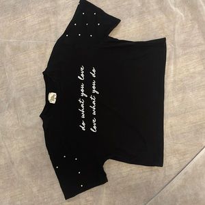 Black crop top, has a quote on the front, has baby pearls on sleeve, light wear